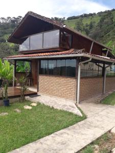 une maison avec une grande fenêtre au-dessus dans l'établissement Casa do Índio, à Visconde de Mauá