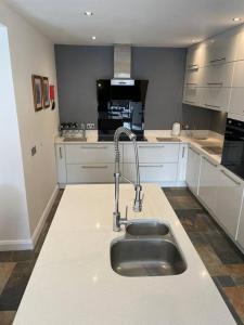 uma cozinha com um lavatório no meio em Luxury Portrush Holiday Homes - The Glynn, Portrush Sleeps 12 - 5 bedrooms em Portrush