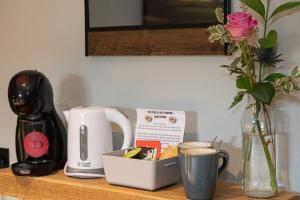 a counter top with a coffee maker and a cup of coffee at The Nog Inn in Wincanton