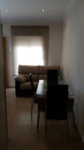 salon z kanapą i stołem z laptopem w obiekcie Apartamento Loyola Tania w mieście Conil de la Frontera