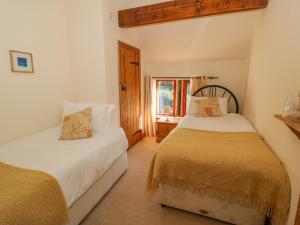A bed or beds in a room at Stables Cottage