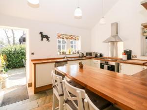 uma cozinha com uma mesa de madeira e cadeiras num quarto em Rose Cottage em Bakewell