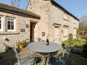a patio with a table and chairs in front of a building at Rose Cottage in Bakewell