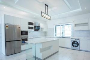 a kitchen with white appliances and a white counter top at Banner Vacation Home & Swimming Pool in Prampram