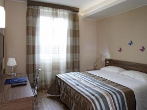 - une chambre avec un lit, un bureau et une fenêtre dans l'établissement Hotel Porta Nuova, à Assise