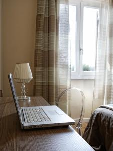 a laptop computer sitting on a table with a lamp at Hotel Porta Nuova in Assisi