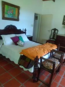 a bedroom with a large bed and two chairs at El Tramway Casa Antigua de Campo in San Antonio de Areco +32 photos