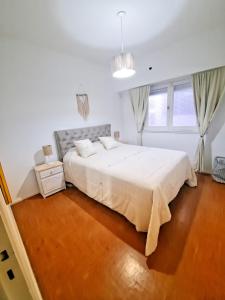 um quarto branco com uma cama grande e janelas em Alojamiento Entero Barrio Agronomia em Buenos Aires