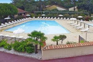 uma grande piscina com espreguiçadeiras e guarda-sóis em Holiday resort La Plage en Médoc Soulac-sur-Mer - SAT01344-IYB em Soulac-sur-Mer