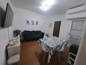 uma sala de estar com uma mesa e um sofá em Alojamiento Entero Barrio Agronomia em Buenos Aires
