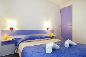 um quarto com uma cama azul com toalhas em Holiday resort La Plage en Médoc Soulac-sur-Mer - SAT01344-IYB em Soulac-sur-Mer
