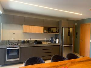 uma cozinha com utensílios de aço inoxidável e uma mesa de madeira em Apartamento família com 3 quartos no Eco Resort Carneiros em Tamandaré