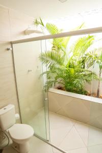 uma casa de banho com um chuveiro, um WC e plantas em Aldeia Maracajaú - Camping & Chalés em Maracajaú
