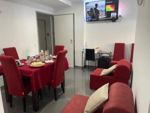 a dining room with a table and red chairs at Ergosuites in Figueira da Foz