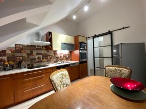 a kitchen with a table and chairs and a refrigerator at Pokoje Gościnne u Kovi in Legnica