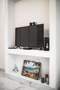 een televisie op een witte plank in een woonkamer bij Apartments Sophia in Kotor