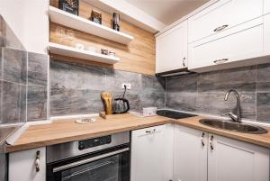 een keuken met witte kasten en een spoelbak bij Apartments Sophia in Kotor