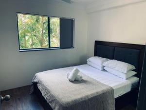 a bed with a teddy bear sitting on top of it at Aruba Surf Resort in Gold Coast +67 photos