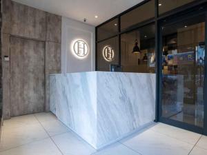 a lobby with a marble counter in a building at Hope Hotel Masai in Masai