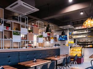 a restaurant with tables and chairs and a bar at Hope Hotel Masai in Masai