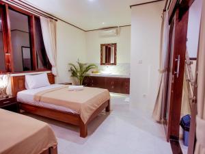 a hotel room with two beds and a bathroom at Bali Laksita Homestay in Canggu