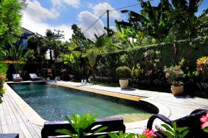 una piscina en un jardín con plantas en Sasa Bali Villas, en Seminyak