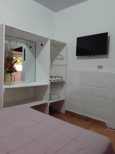 a bedroom with a bed and a tv on a wall at Apartamento Hogareño in Jarabacoa