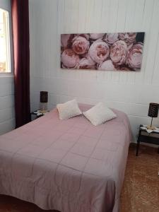 1 dormitorio con 1 cama con rosas rosas en la pared en Apartamento Hogareño, en Jarabacoa