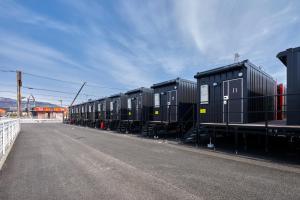 a row of train cars parked on the side of a road at HOTEL R9 The Yard Tarui in Tarui