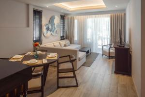- un salon avec un canapé et une table dans l'établissement The Pe La Resort, Phuket - SHA Extra Plus, à Kamala Beach