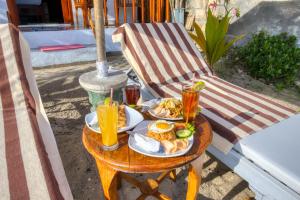 uma mesa com um prato de comida e bebidas numa cadeira em Sari Nadi Beach em Nusa Penida