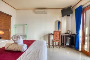 a bedroom with a bed and a table and a chair at Sari Nadi Beach in Nusa Penida