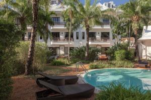 a resort with a swimming pool and a building at The Pe La Resort, Phuket - SHA Extra Plus in Kamala Beach