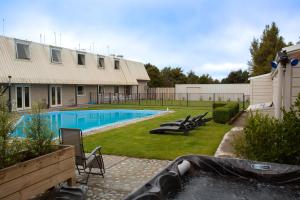 a backyard with a swimming pool and a building at Southern Cross Lodge Methven in Methven