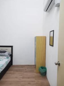 1 dormitorio con 1 cama y armario de madera en Homestay De' Humaira - USM Nibong Tebal, en Nibung Tebal