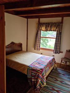 1 dormitorio con cama y ventana en Chalé na Serra da Mantiqueira, en Campos do Jordão