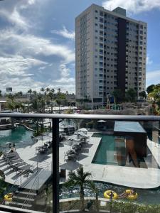 - une vue sur une piscine avec des chaises et un bâtiment dans l'établissement Salinas Premium Resort - Salinópolis PA, à Salinópolis