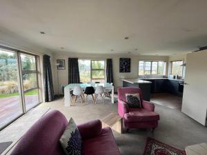 a living room with a couch and a table and chairs at Sam's Place in Lake Tekapo