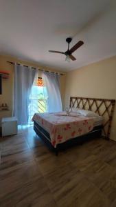 a bedroom with a bed and a ceiling fan at Pousada Camping dos Ypês in Guapimirim