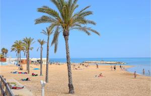un grupo de personas en una playa con palmeras en Nice Home In Marina Di Modica With Wifi, en Marina di Modica
