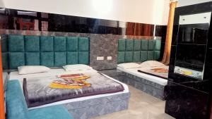 a room with two beds and a mirror at Vidya Guest House in Katra
