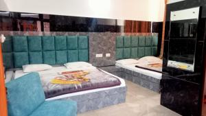 a room with two beds and a chair in it at Vidya Guest House in Katra