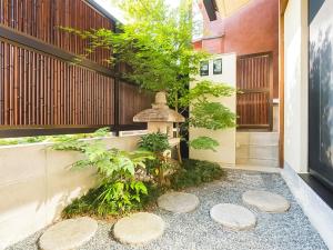 a japanese garden with a fountain in a building at Kyoto Earth Hotel in Kyoto