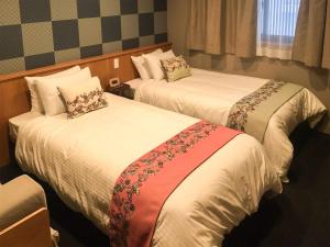 Postel nebo postele na pokoji v ubytování Kyoto Earth Hotel