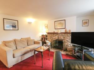 a living room with a couch and a fireplace at River Cottage in Burton Bradstock
