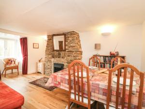 a bedroom with a bed and a stone fireplace at River Cottage in Burton Bradstock