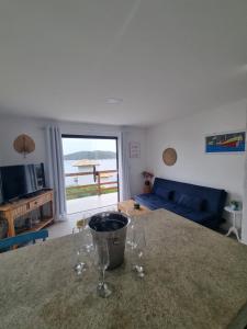 una sala de estar con una mesa con copas de vino. en Casa Corazul, en Arraial do Cabo