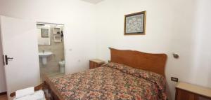 a bedroom with a bed and a bathroom with a sink at La Casa in Piazza in Gubbio