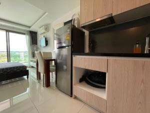 a kitchen with a stainless steel refrigerator and a table at LAGUNA BEACH 3 MALDIVES in Jomtien Beach