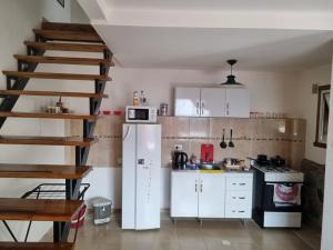 una cocina con nevera blanca y una escalera en Tu hogar en el fin del mundo en Ushuaia